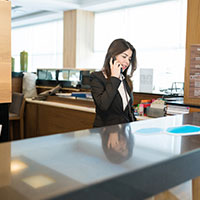 female hotel reception desk clerk on the phone