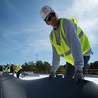 roofer installing EPDM membrane